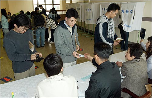 9일 오후 연세대 학생들이 부재자 투표소에서 기표를 하기 앞서 선관위 관계자에게 신분증을 제시하고 있다. 